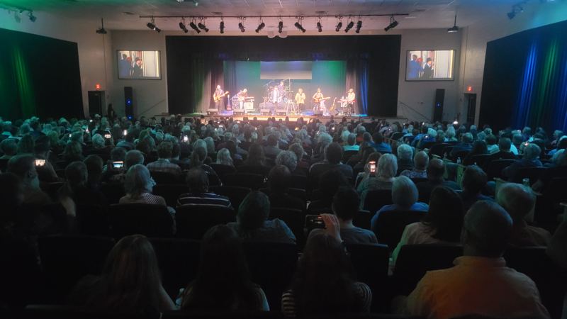 Full auditorium watching a lit stage