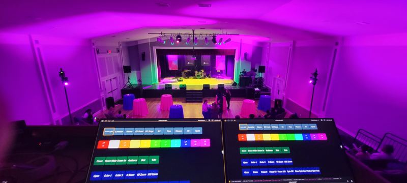 Event hall washed in magenta, seen from the lighting control screens